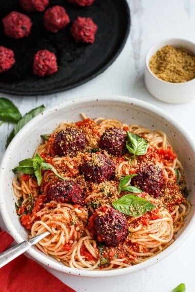 素食主义者意大利面条和甜菜！ A beautiful twist on the comforting familiar classic.  Beets, black beans, walnuts and basil make these plant-based meatballs scrumptious and so satisfying.  Top with an easy rustic tomato sauce for a meal the whole family will love! #vegan #veganmeatballs #beetballs #spaghetti #veganspaghetti