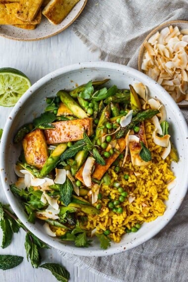 美味的椰子饭碗健康且适应能力！ Curried jasmine rice cooked in coconut milk and topped with tofu or your choice of protein and seasonal vegetables.  All tossed with a simple, flavorful sauce, fresh cilantro, mint and toasted coconut flakes.